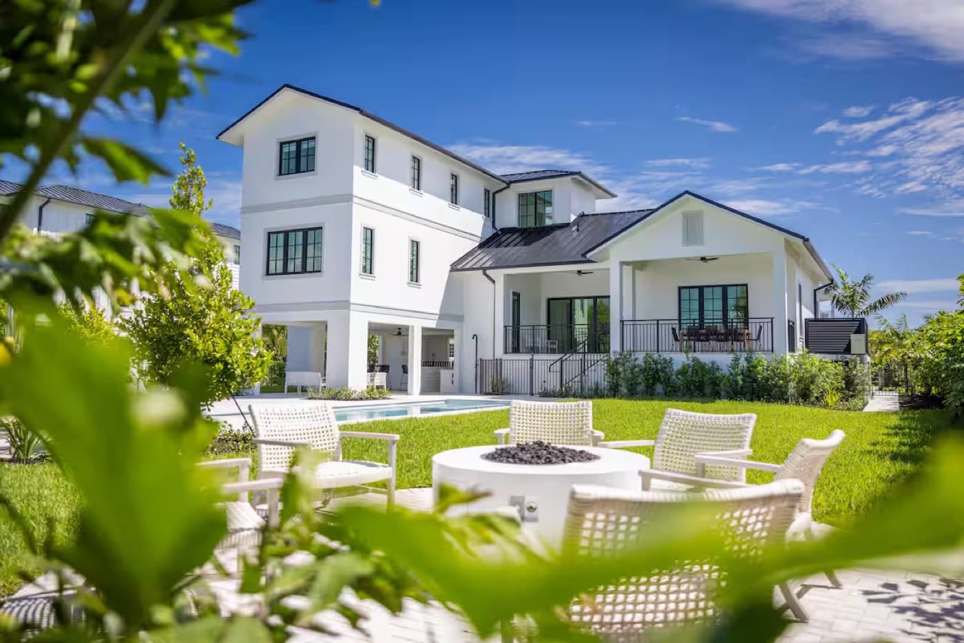 A coastal white estate with a firepit lawn