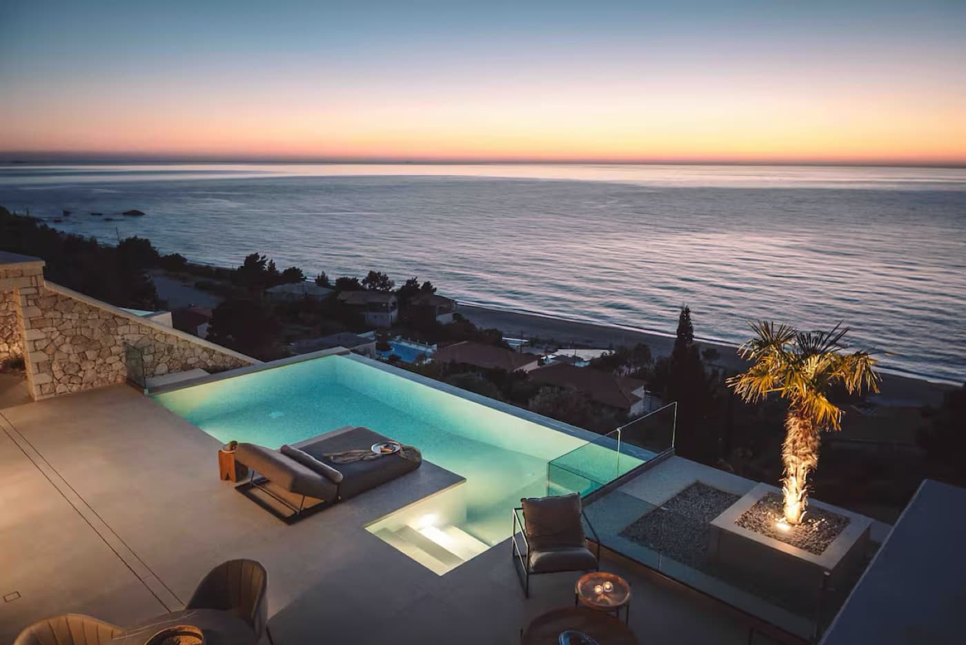 A clifftop infinity pool meeting the sea at dusk